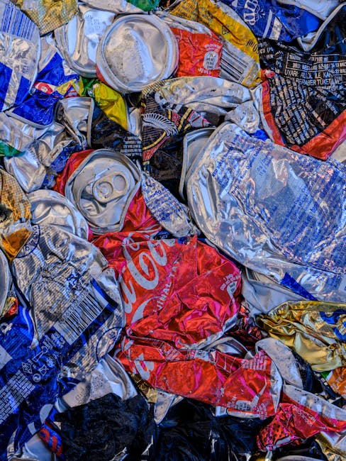 A large pile of black garbage bags is stacked against a modern tiled wall outdoors, with some plastic bottles and assorted waste materials visible protruding from the bags. The bags vary in size and a